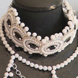 Des colliers de perles sur un mannequin.