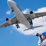 Plane-spotting enthusiast Jean-Charles Hubert takes some photographs as an Air Transat Airbus A330 lands at Montreal's Trudeau Airport on July 31, 2016. (Graham Hughes/The Canadian Press)