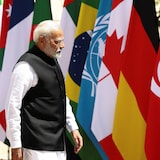 M. Modi passant devant des drapeaux de plusieurs nations.