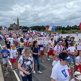 A gathering of people sporting Acadian shirts and flags.