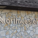 A Northwestel sign on a stone wall. 