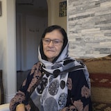 Une femme assise dans un fauteuil.