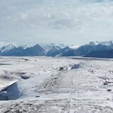 An icy terrain with snowy mountains in the background. 