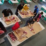 Des personnes préparent de la viande au Centre alimentaire communautaire Qajuqturvik. 