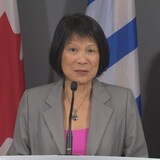 عمدة تورونتو أوليفيا تشاو تتحدث واقفة في مؤتمر صحفي.