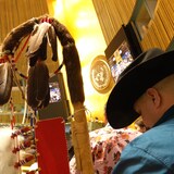 Cheyenne Kitchikake tient un bâton recouvert de plumes dans la salle de l'ONU.