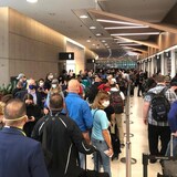 Une centaine de passagers qui attendent à l'aéroport.