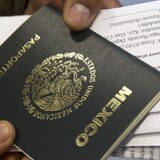 Una persona sostiene un pasaporte mexicano.