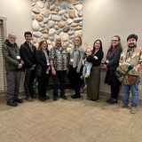 Les membres du projet de revitalisation de la langue pentl'ach sont réunis devant une cheminée.