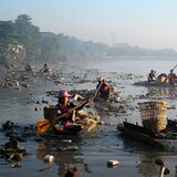 Une dizaine de personnes flottent sur des embarcations de polystyrène à la recherche de plastique et de verre à recycler parmi les déchets qui flottent dans la crique de Pazundaung, à Rangoon, au Myanmar.