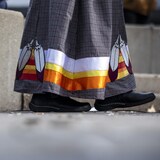 Una mujer indígena lleva puesta una falda de cintas.