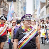 Des femmes marchent sur la rue Yonge à Toronto dans le cadre du défilé de la Fierté, le 26 juin 2022.