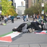 Personas rezan en la calle.
