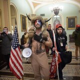 Grupo de manifestantes, uno de ellos con cuernos, en el Capitolio.