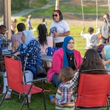 De nouveaux arrivants socialisent dans un parc à l'extérieur. 