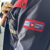 Le logo de Postes Canada sur le manteau d'une travailleuse.