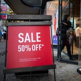 A sign announcing a 50% off sale outside a store on Black Friday.