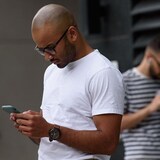 Cellphone users in Toronto fiddle with their phones.