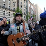 Sean Feucht holding his guitar during a protest.