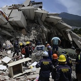 Firefighters and rescue workers near a building that collapsed following a double earthquake in Los Corales, in La Guaira State, about 38 km (24 miles) northwest of Caracas, on June 25, 2026.