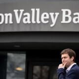 A customer stands outside of the shuttered headquarters of Silicon Valley Bank on Friday in Santa Clara, Calif. The bank was shut down by regulators on Friday. (Justin Sullivan/Getty Images)