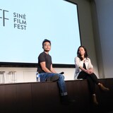 Sina Carlo Mendoza at Justine Abigail Yu nakaupo sa stage habang mababasa sa likod ang Sine Film Fest.