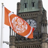 The Survivors' flag flies on Parliament Hill beside the Peace Tower on Monday in Ottawa.