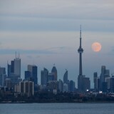 Ang buwan makikita sa likod ng skyline ng lungsod ng Toronto.