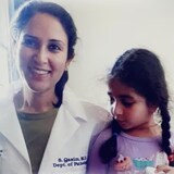 Syeda Qasim, left, with her daughter, wore a doctor’s white coat for the first time after six years as she celebrated her acceptance into a pathology residency in New Jersey in 2021. (Submitted by Syeda Qasim)