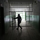 Un guardia abre la puerta de una prisión.