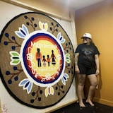 Chastity Shingoose McNab à côté d'un de ses tapis.