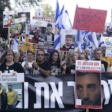 Les familles des otages et leurs sympathisants brandissent des photos des otages lors d'une manifestation appelant à un accord pour leur libération, le 17 août 2025 à Tel-Aviv.