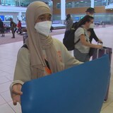 Sherafa holds up the small yoga mat she was given to sleep on for the night at Toronto's Pearson airport after her flight to Winnipeg was cancelled.