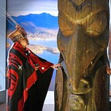 Dos miembros de la Primera Nación Nisga'a junto al tótem de la casa Ni'isjoohl en el Museo Nacional de Escocia.