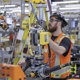 عامل يقوم بتجميع أجزاء سيارة كهربائية في مصنع ’’جنرال موتورز‘‘ في مدينة إنجرسول في مقاطعة أونتاريو.