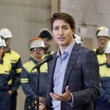 Justin Trudeau parle dans un micro. Il regarde l'objectif. 