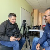 Deux hommes assis parlent et sourient. Il s'agit d'Ernesto Méndez Jaramillo et Alberto Aguilera qui produisent la série télévisée Me voy pal norte sur TV4 Guanajuato.