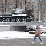 Une jeune femme passe devant un char T-34 soviétique de la Seconde Guerre mondiale, le 25 janvier 2022 à Kiev, en Ukraine. 