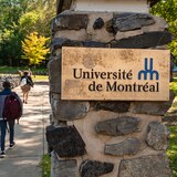 طلاب يمرون قرب لوحة مكتوب عليها ’’جامعة مونتريال‘‘.
