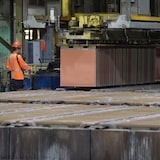 Un employé observe le retrait des feuilles de cathodes de cuivre des anodes de cuivre pendant l'électrolyse à la Canadian Copper Refinery (CCR), qui fait partie du groupe Glencore, une raffinerie de cuivre et de métaux précieux située à Montréal, le vendredi 25 juillet 2025. 