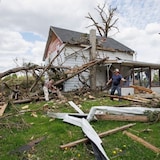Uxbridge, Ont., resident Allen Harrison cleans up his property on Tuesday, after a tornado produced by a derecho swept through the southern Ontario town. (Evan Mitsui/CBC)