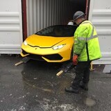 Nakatingin ang lalaki sa luxury car na nasa loob ng container sa isang port sa Montreal.