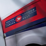 Des véhicules de Postes Canada sont garés.
