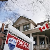 لافتة أمام منزل مرفوع عليه علم كندا تفيد بأنه معروض للبيع.