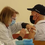 ممرضة تعطي رجلاً لقاحاً ضد الكوفيد-19 في منطقة ’’سان لوران السفلى‘‘ في مقاطعة كيبيك في خريف 2023.