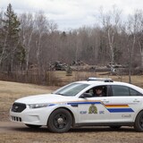 Voiture de la GRC devant des ruines.