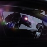 شخص مقنّع يحمل مصباحاً كهربائياً يحاول سرقة سيارة في الظلام. 