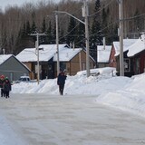 Des enfant s'amusent dans une rue de Wemotaci, en hiver