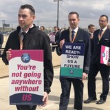 Les pilotes tiennent des affiches avec différents slogans sur leurs revendications.
