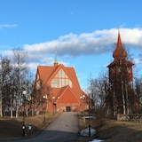 A picture of a wooden church amongst trees. 